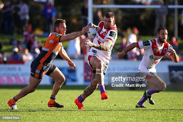 Josh Dugan of the Dragons is tackled during the round 26 NRL match between the St George Illawarra Dragons and the Newcastle Knights at WIN Jubilee...