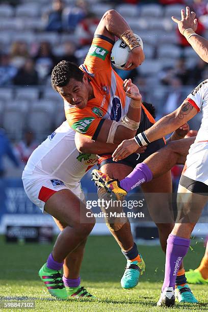 Daniel Saifiti of the Knights is tackled during the round 26 NRL match between the St George Illawarra Dragons and the Newcastle Knights at WIN...