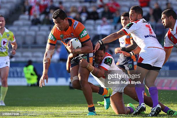 Daniel Saifiti of the Knights is tackled during the round 26 NRL match between the St George Illawarra Dragons and the Newcastle Knights at WIN...