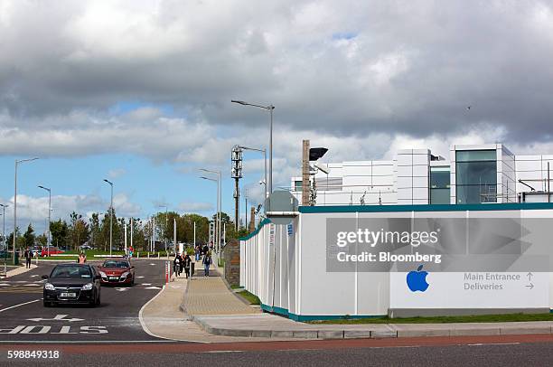 An Apple Inc. Logo is displayed on a sign in front of hoarding boards as traffic drives past the company's campus in Cork, Ireland, on Friday, Sept....