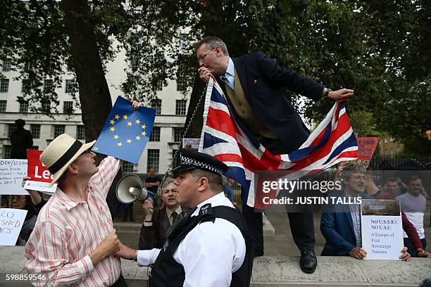 Police officer seperates a pro-Europe anti-Brexit demonstrator on a March for Europe from a pro-Brexit demonstrator forming a counter protest stood...