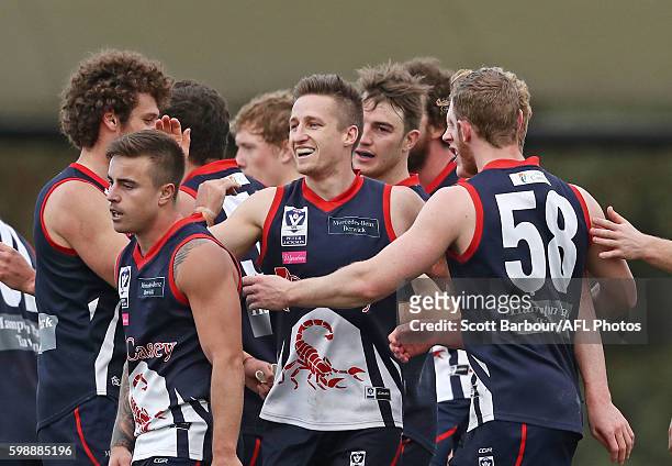 Jack Grimes of Casey Scorpions is congratulated by his teammates after kicking a goal during the VFL Qualifying Final match between Casey and...