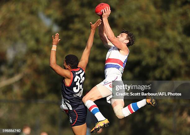 Anthony Barry of Footscray marks the ball against Aloysio Ferreira of Casey Scorpions during the VFL Qualifying Final match between Casey and...