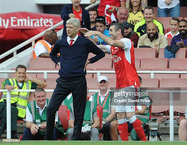 Martin Keown of Arsenal Legends pretends to strangle Arsenal Manager Arsene Wenger during the Arsenal Foundation Charity match between Arsenal...