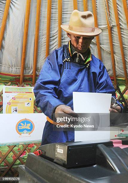 Mongolia - A man casts his vote at a polling station for a general election in a ger, a portable home for nomads, in Khovd, western Mongolia, on June...