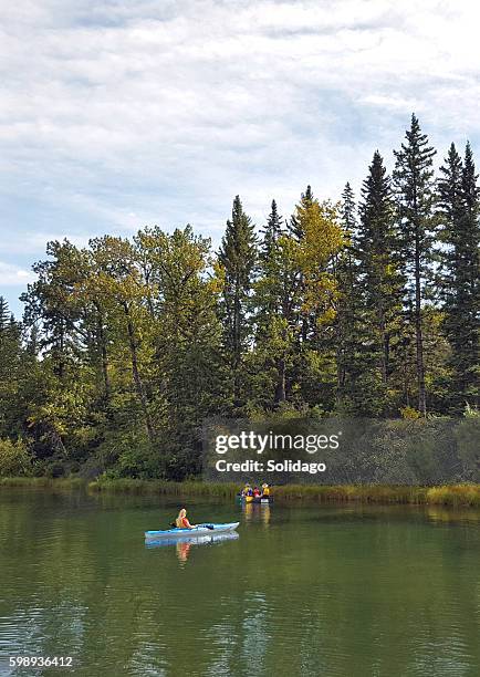 peaceful afternoon floating on the lagoon - family red canoe stock pictures, royalty-free photos & images
