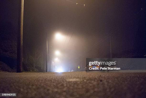 low angle view of urban street in fog at night - rear light car stock pictures, royalty-free photos & images