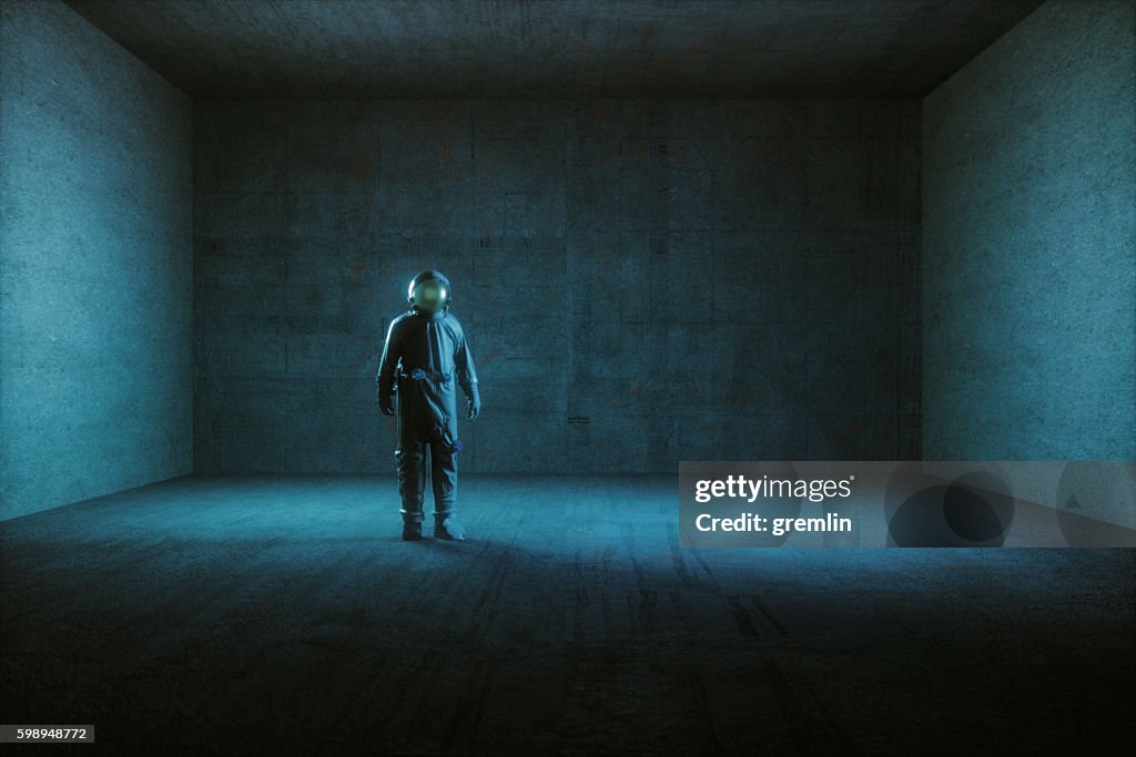Astronaut standing in empty spaceship room