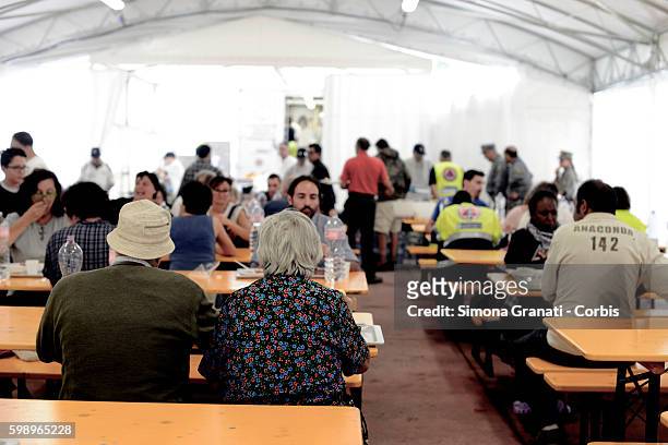 People eat in the canteen area of the tent camp erected for earthquake victims on August 31, 2016 in Arquata del Tronto, Italy. The region was struck...