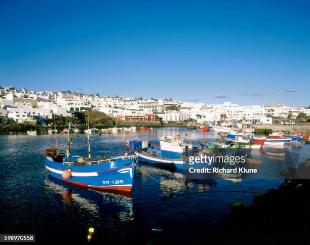 fishing boats moored in puerto del carmen harbor - puerto del carmen stockfoto's en -beelden