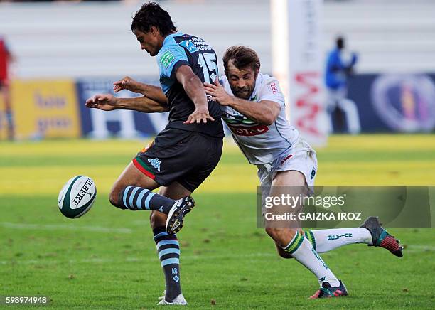 Bayonne's Argentinian fullback Martin Bustos Moyano is tackled by Pau's New Zealander center Conrad Smith during the French Top 14 rugby union match...