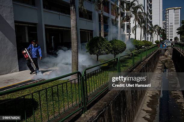 Pest control worker fumigates the grounds of apartment block in Aljunied on September 3, 2016 in Singapore. Singapore raised the number of Zika cases...