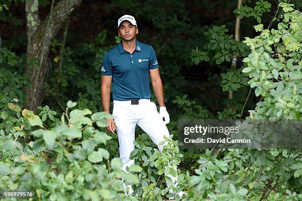 Jason Day of Australia stands in the trees as he looks to play his shot on the fifth hole during the second round of the Deutsche Bank Championship...