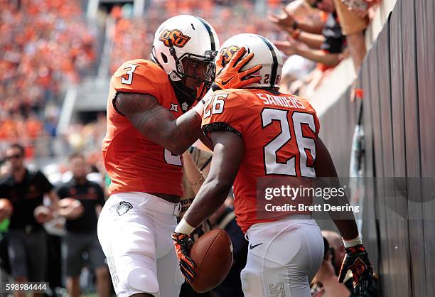 Wide receiver Marcell Ateman congratulates running back Barry Sanders of the Oklahoma State Cowboys after a score against the Southeastern Louisiana...