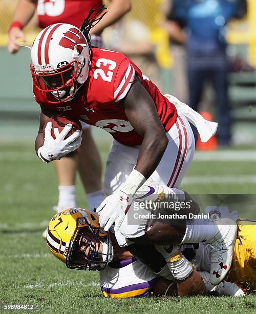 Dare Ogunbowale of the Wisconsin Badgers is tackled by Duke Riley of the LSU Tigers during the first half at Lambeau Field on September 3, 2016 in...