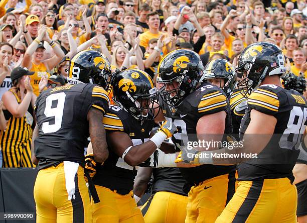 Running back Akrum Wadley of the Iowa Hawkeyes celebrates with wide receiver Jerminic Smith and offensive lineman Sean Welsh after scoring a...