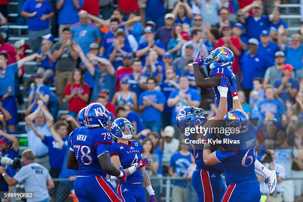 Steven Sims Jr. #11 of the Kansas Jayhawks celebrates with his team after scoring a touchdown against the Rhode Island Rams defense in the first half...