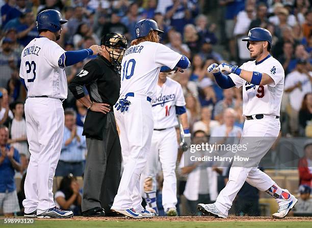 Yasmani Grandal of the Los Angeles Dodgers celebrates his three run homerun to take a 4-0 lead over the San Diego Padres with Justin Turner and...