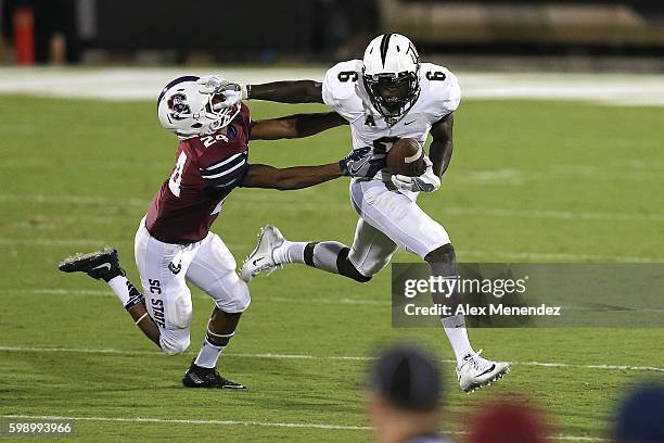 Tristan Payton of the UCF Knights straight arms Lynard Jamison of the South Carolina State Bulldogs during a NCAA football game at Bright House...