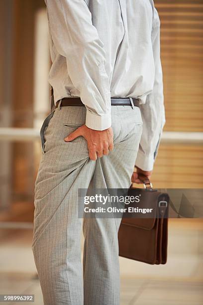 businessman squeezing his behind - oliver eltinger stock pictures, royalty-free photos & images