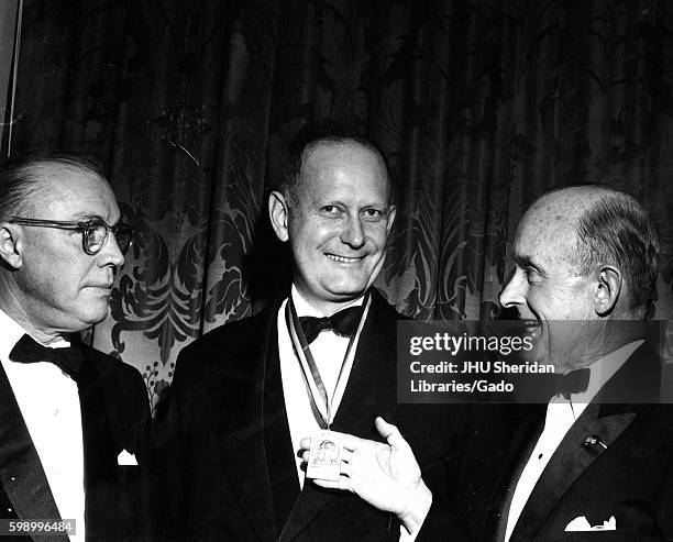 Candid group of President of Johns Hopkins University President speaking with Secretary of the Treasury C. Douglas Dillon during the Lafayette...