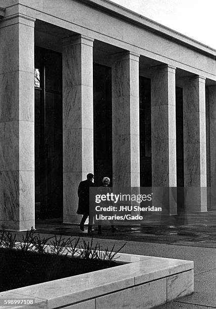 The entrance of newly opened Milton S Eisenhower Library at Johns Hopkins University from the terrace level, with a man and a woman walking side by...