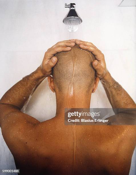 young man with shaved head showering - shaved head ストックフォトと画像
