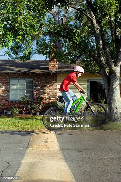 boy riding bicycle - wheelie stock-fotos und bilder