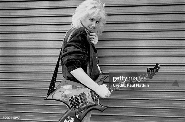Portrait of American Rock musician Lita Ford as she poses outdoors with guitar, Los Angeles, California, March 18, 1985.