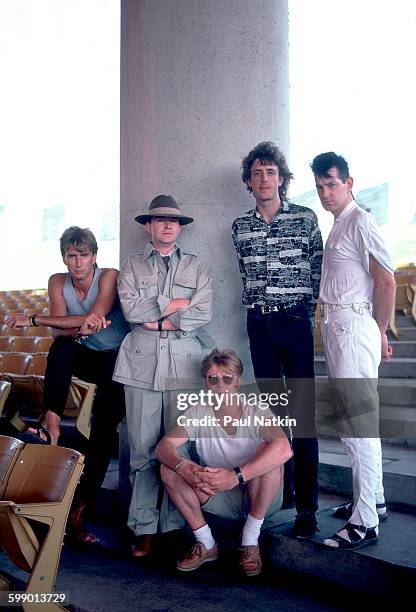 Portrait of British New Wave group the Fixx as they pose outdoors at the Poplar Creek Music Theater, Hoffman Estates, Illinois, July 5, 1986....