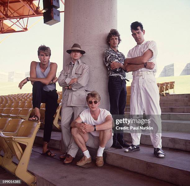 Portrait of British New Wave group the Fixx as they pose outdoors at the Poplar Creek Music Theater, Hoffman Estates, Illinois, July 5, 1986....