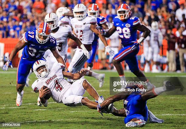 Sekai Lindsay of the Massachusetts Minutemen is tackled during the second half of the game against the Florida Gators at Ben Hill Griffin Stadium on...