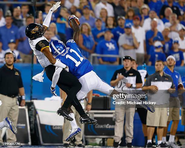 As Walden Davis of the Southern Miss Golden Eagles goes up for the pass but J.D. Harmon of the Kentucky Wildcats makes the interception at...