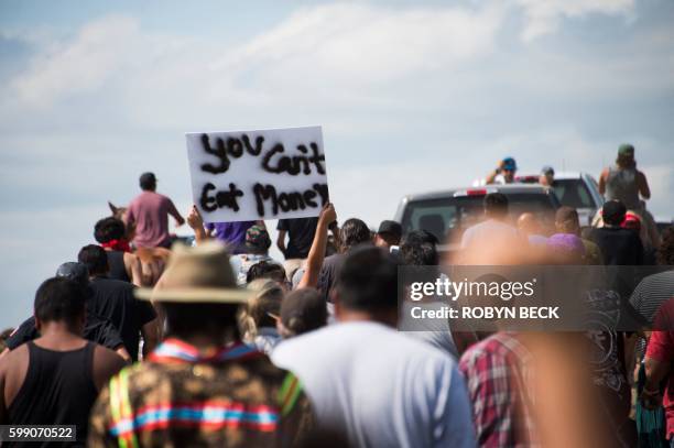 Private security guards in pick-up trucks drive away as Native Americans protestors and their supporters advance on land designated for the Dakota...