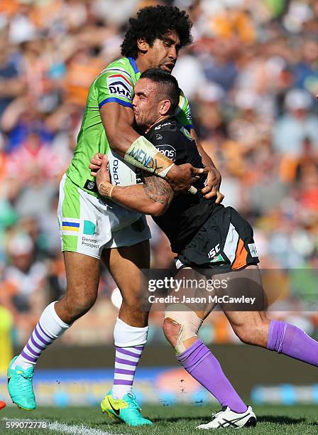 Dene Halatau of the Tigers is tackled by Iosia Soliola of the Raiders during the round 26 NRL match between the Wests Tigers and the Canberra Raiders...