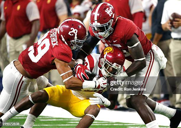 Minkah Fitzpatrick and Ronnie Harrison of the Alabama Crimson Tide tackle Deontay Burnett of the USC Trojans in the second half during the AdvoCare...