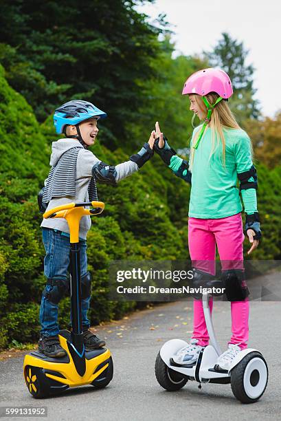 Happy kids standing on hoverboard or gyroscooter outdoor