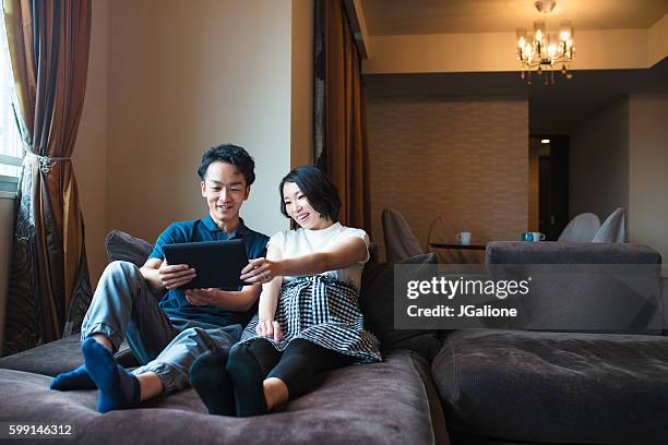 couple looking at a digital tablet together - loving 2016 film stock pictures, royalty-free photos & images