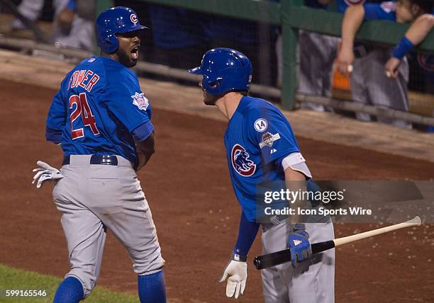 Chicago Cubs center fielder Dexter Fowler reacts with third baseman Kris Bryant after scoring on an an RBI single by left fielder Kyle Schwarber...