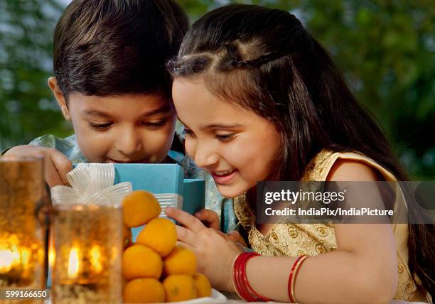 boy and girl opening gifts on diwali - diwali sweets stock pictures, royalty-free photos & images