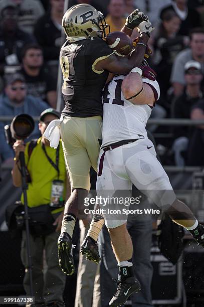 Purdue University cornerback Anthony Brown breaks up a pass for Minnesota Gophers fullback Miles Thomas during a NCAA football game between the...
