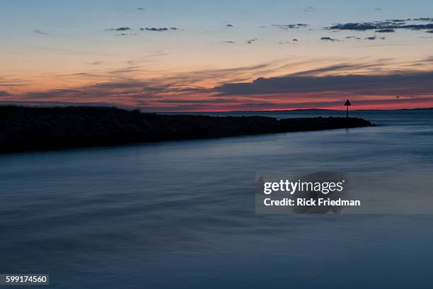 Sunset over Menemsha Sound in the town of Chilmark on Martha's Vineyard, MA over looking beach in the town of Aquinnah, formerly known at Gay Head on...