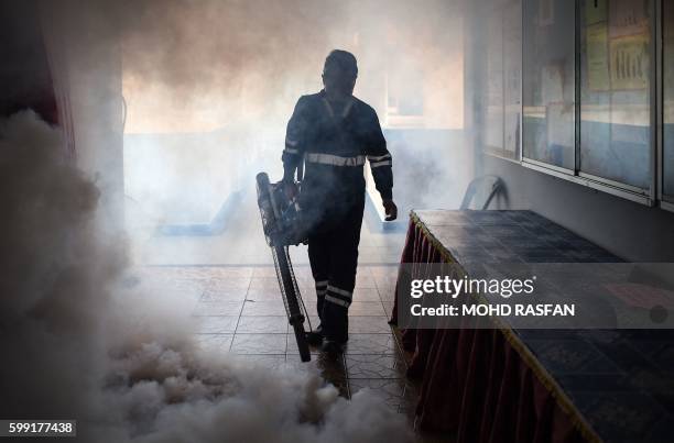 Pest control worker fumigates a school classroom on the eve of the annual national Primary School Evaluation Test in Kuala Lumpur on September 4,...