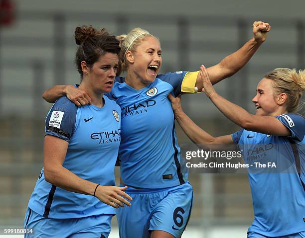 Jennifer Beattie of Manchester City Women celebrates with team-mate Steph Houghton and Izzy Christiansen after she scores her sides first goal during...