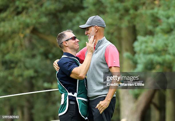 Andre Bossert of Switzerland is congratulated by his caddie after winning the Travis Perkins Masters played on the Duke's Course at Woburn Golf Club...