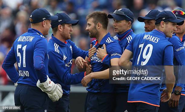 England bowler Mark Wood celebrates with teammates after taking the wicket of Pakistan's Babar Azam during play in the fifth one day international...