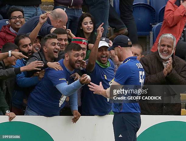 England's Ben Stokes collects the ball from a member of the crowd who has caught the ball, hit for six by Pakistan batsman Sarfraz Ahmed during play...
