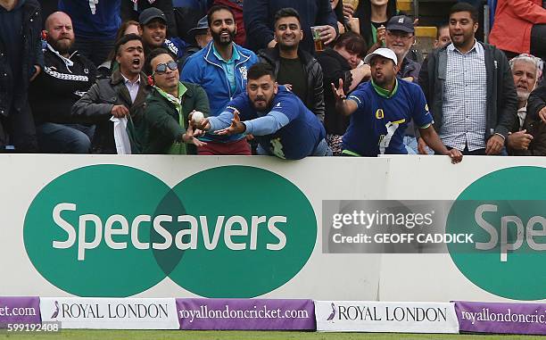 Member of the crowd catches a ball hit for six by Pakistan batsman Sarfraz Ahmed during play in the fifth one day international cricket match between...