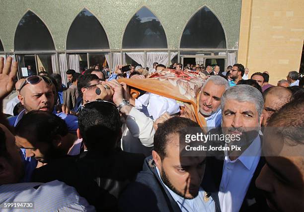Khaled Mashal , the leader of the Islamic Palestinian organization HAMAS, raises the body of his mother during her funeral on September 4 in Amman,...
