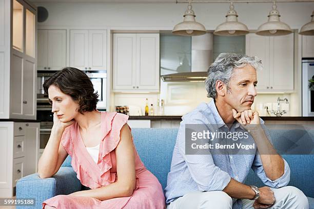 sad couple sitting back to back - relationship difficulties stock pictures, royalty-free photos & images